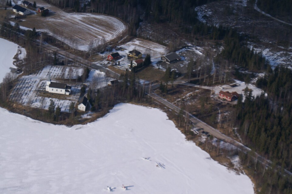 VEMUNDSJØEN: Flyfotoet viser Åsnes Finnskog kirke til venstre og Café Finnskog opp mot høyre. VEMUNDSJØEN: Flyfotoet viser Åsnes Finnskog kirke til venstre og Café Finnskog opp mot høyre.