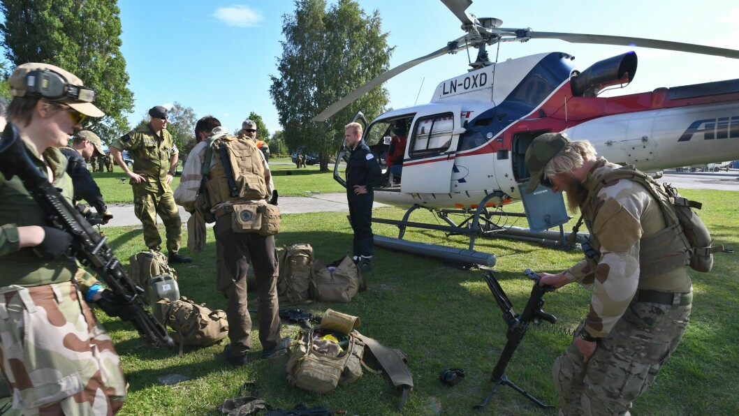 HV-mannskaper laster ombord våpen og annet utstyr i det sivile helikopteret for forflytning til øvelsesområdet.