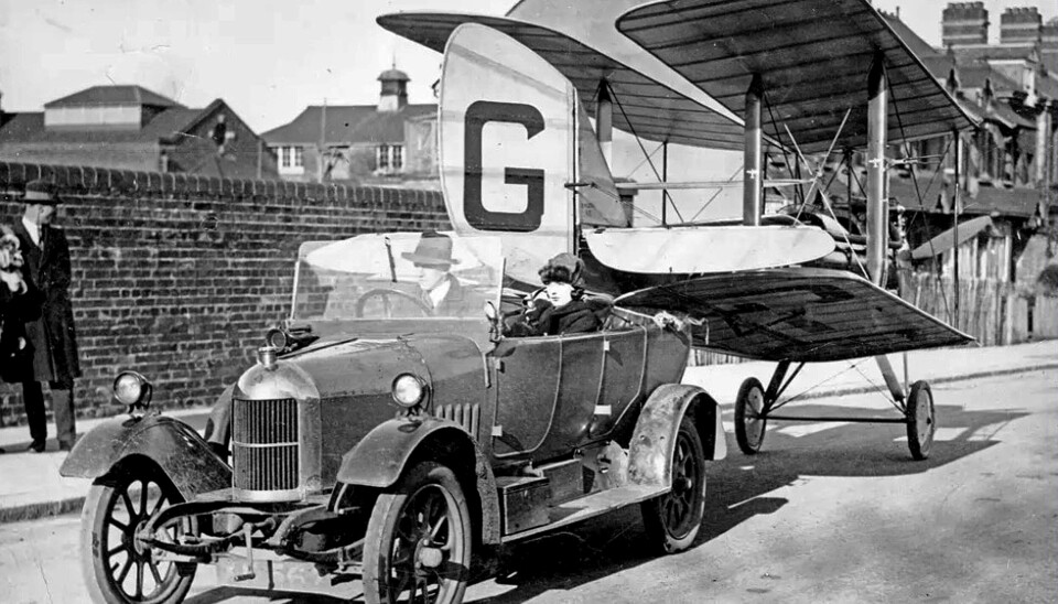 Vingene på D.H. 60 Moth kunne foldes, slik at flyet ikke krevde mye hangarplass, og det kunne trekkes etter bilen til og fra flyplassen. Det er prototypen G-EBKT som ses her, så man kan anta at det er et arrangert reklamefoto. Det er nok tvilsomt om mange kjørte rundt med Mothen sin på slep. Prototypen ble brukt som demonstrasjonsfly, før den i 1926 ble solgt til Sophie C. Elliot Lynn, som året etter solgte den til London Aeroplane Club. Noen måneder etter eierskiftet var en RAF-offiser på en søndagstur med sin kone, da de havarerte under et besøk hos en adelsmann. De to overlevde styrten, men Moth-en gjorde dessverre ikke det. Foto: OSH arkiv